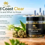 Gold Coast Clear branded jar displayed on a wooden surface with coastal scenery and cannabis leaves in the background.